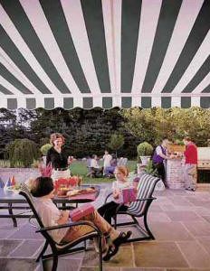 families take shelter from the sun under awnings